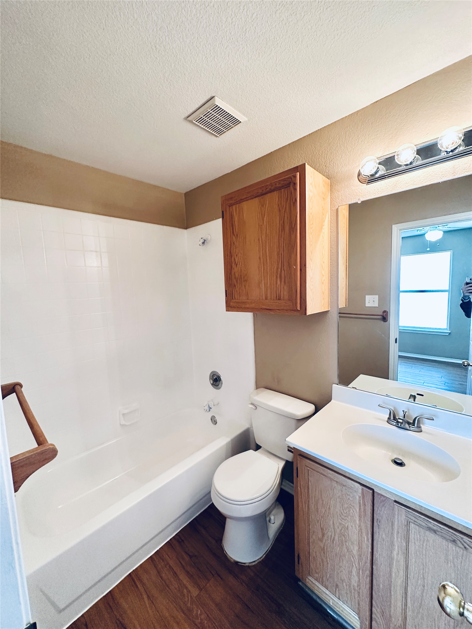 8814 Schick Road, Unit B Austin, TX 78729 - Photo 34 of 36 Full bathroom featuring vanity, dark wood-style flooring, washtub / shower combination, and a textured ceiling