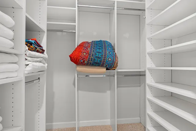 a view of walk in closet with clothes and shoes