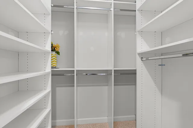 a view of walk in closet with empty racks