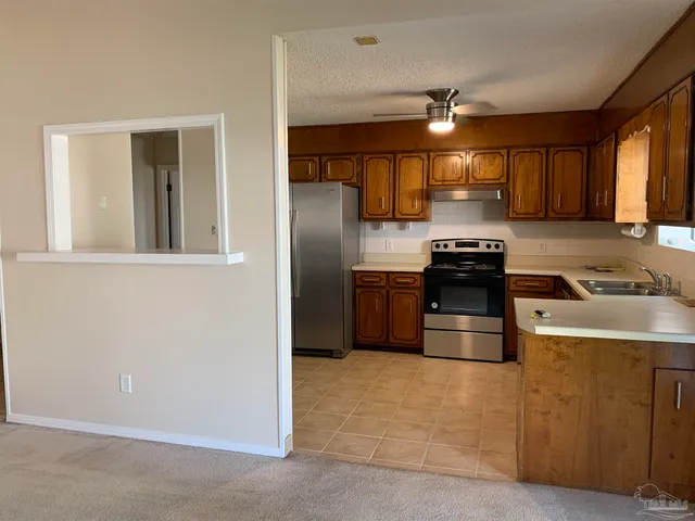 a kitchen with stainless steel appliances granite countertop a stove a sink and a refrigerator