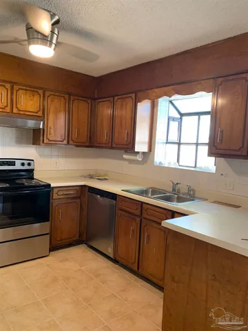 a kitchen with stainless steel appliances granite countertop a sink stove and cabinets