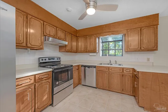 a kitchen with stainless steel appliances granite countertop a sink stove and cabinets