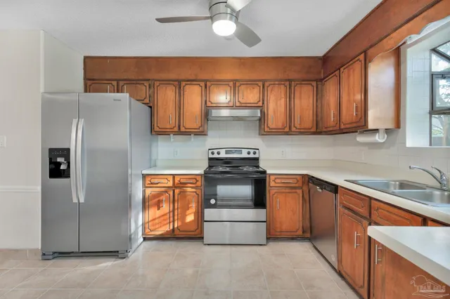 a kitchen with stainless steel appliances granite countertop a refrigerator sink and stove