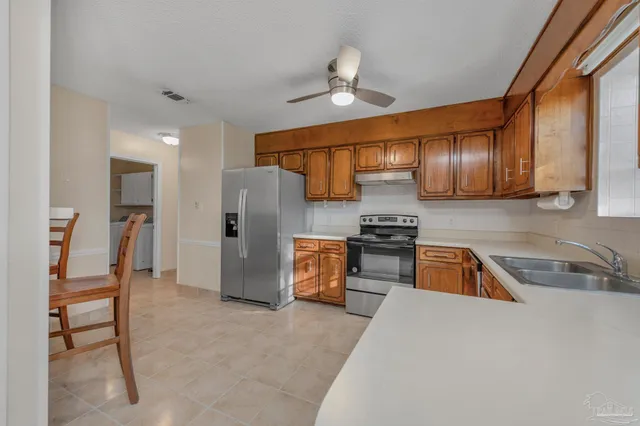 a kitchen with stainless steel appliances granite countertop a sink refrigerator and cabinets