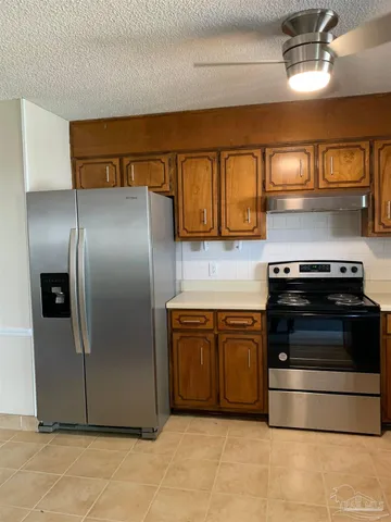 a kitchen with stainless steel appliances granite countertop a stove and a refrigerator