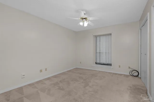 a view of an empty room with a chandelier fan