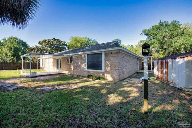 a backyard of a house with barbeque oven table and chairs