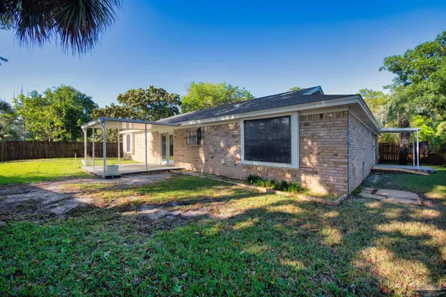 a view of a house with backyard and sitting area