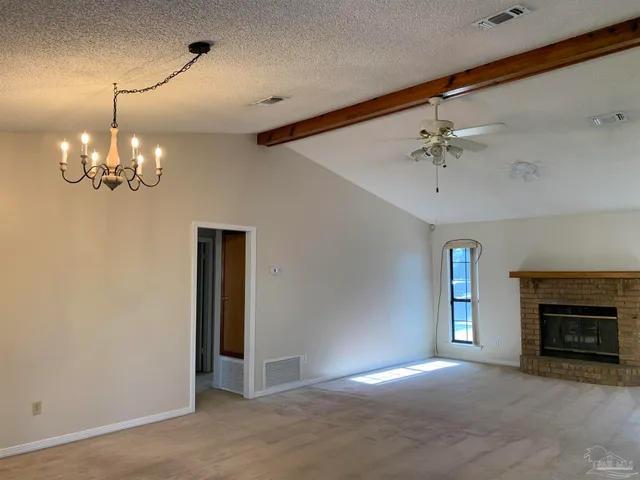 a view of a livingroom with a chandelier fan and a fireplace