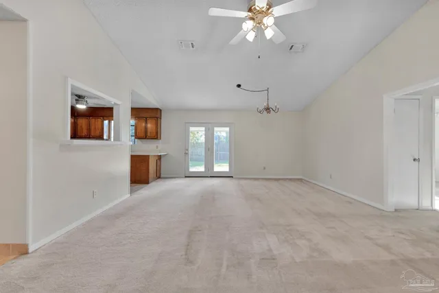 en empty room with windows and fireplace