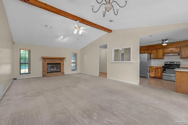 a view of an empty room with a window and fireplace