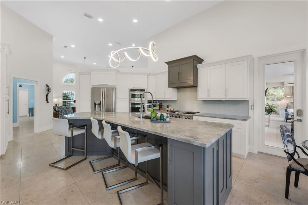 2041 Prince Drive Naples, FL 34110 - Photo 12 of 31 a kitchen with stainless steel appliances granite countertop counter space a sink refrigerator and cabinets