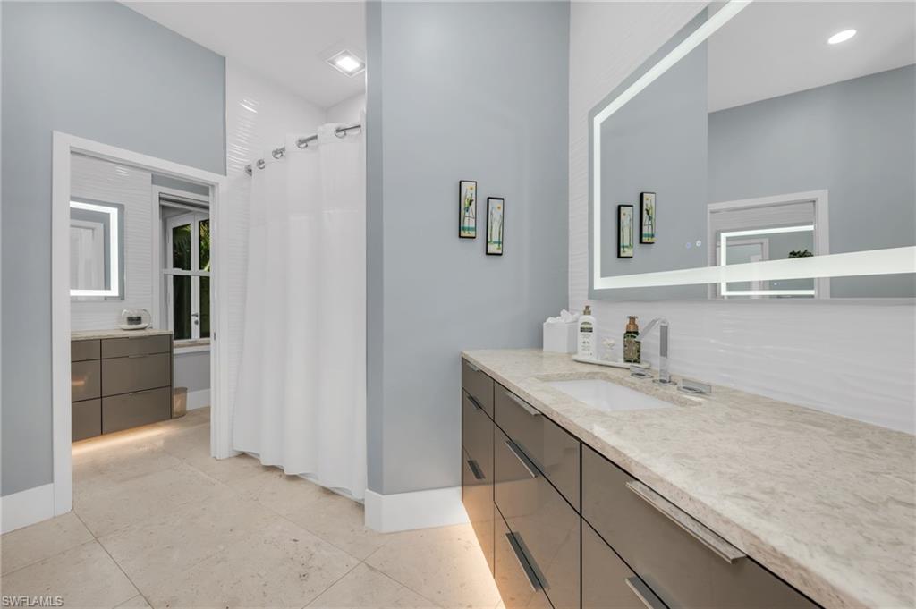 2041 Prince Drive Naples, FL 34110 - Photo 23 of 31 a bathroom with a granite countertop sink mirror and cabinets