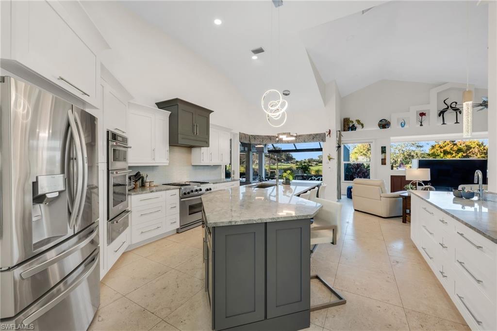 2041 Prince Drive Naples, FL 34110 - Photo 10 of 31 a kitchen with stainless steel appliances kitchen island granite countertop a lot of counter top space