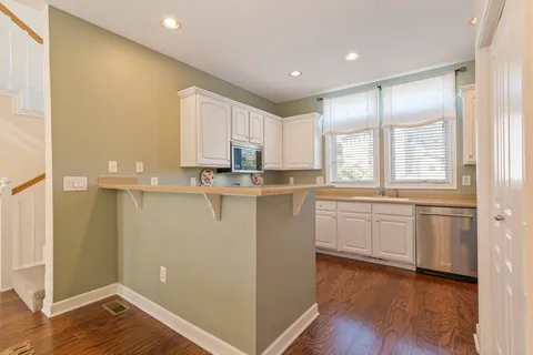 a kitchen with granite countertop white cabinets and white appliances