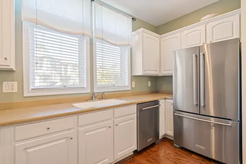 a kitchen with stainless steel appliances white cabinets and a window