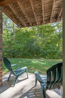 a view of a chairs and backyard with wooden fence