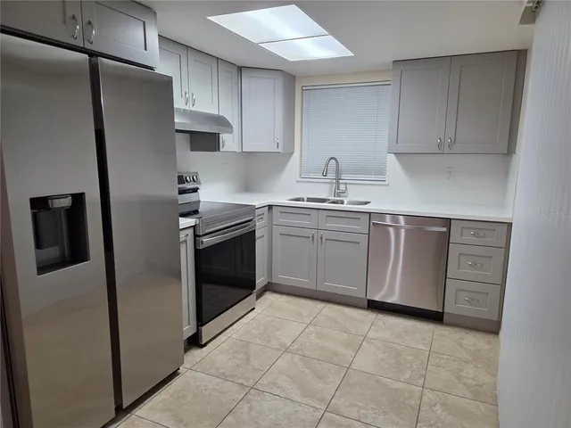 a kitchen with stainless steel appliances granite countertop a refrigerator sink and cabinets