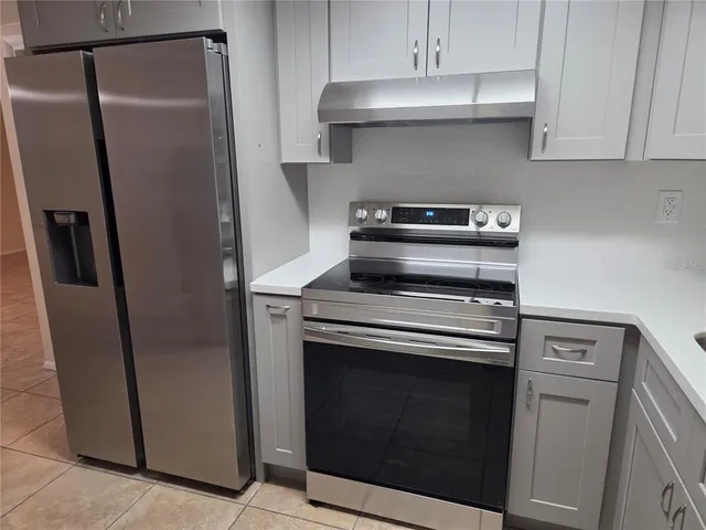 a kitchen with stainless steel appliances wooden floor sink and a stove