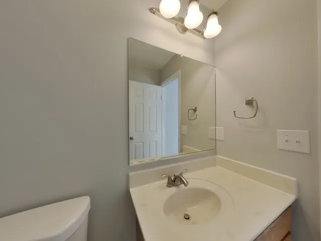 a bathroom with a sink a toilet and a mirror