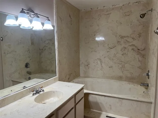 a bathroom with a granite countertop sink a toilet and shower