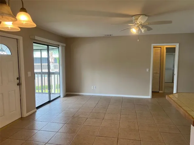 a view of an empty room with a chandelier fan