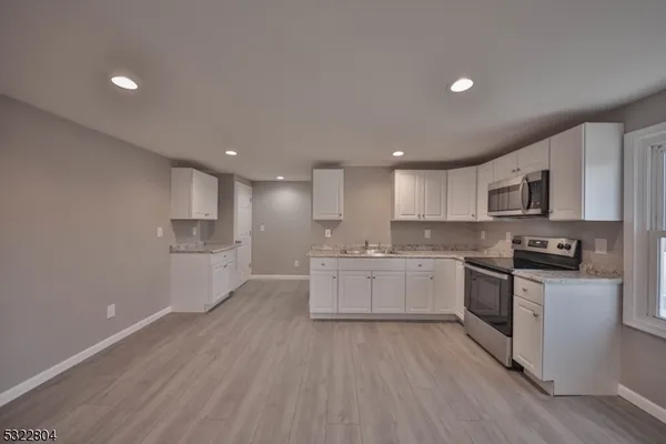 a kitchen with a white wooden cabinets and white appliances