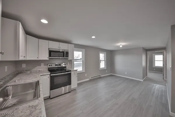 a kitchen with stainless steel appliances granite countertop a stove a sink and a microwave