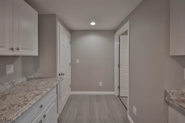 an empty room with wooden floor and cabinet