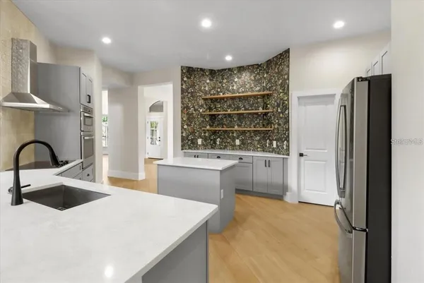 a kitchen with kitchen island a sink appliances and cabinets