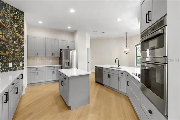 a kitchen with stainless steel appliances granite countertop a sink stove and refrigerator