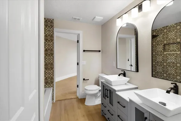a bathroom with a double vanity sink mirror and toilet