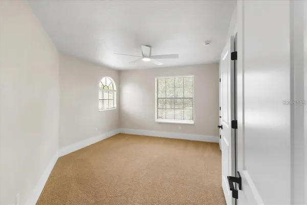 an empty room with windows and closet