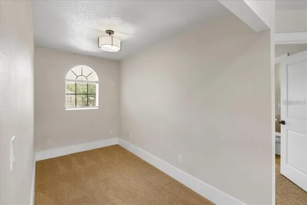 an empty room with windows and mirror