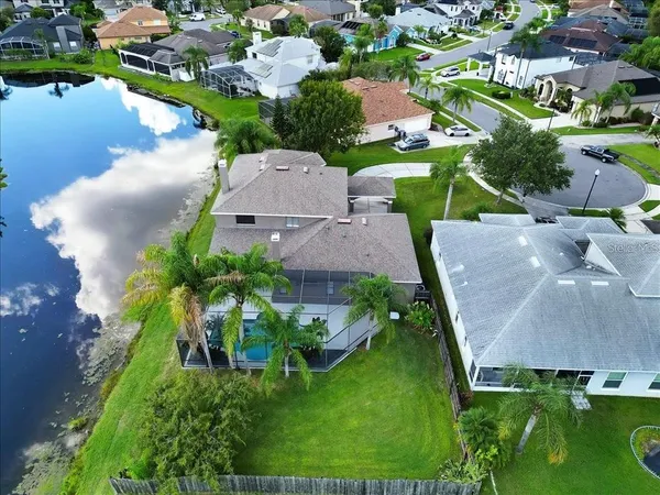 an aerial view of a house with a garden and lake view