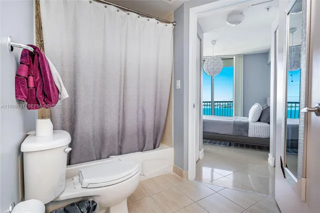 a bathroom with a toilet a sink and curtain