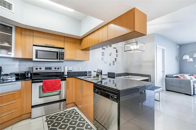 a kitchen with stainless steel appliances granite countertop a sink stove and cabinets