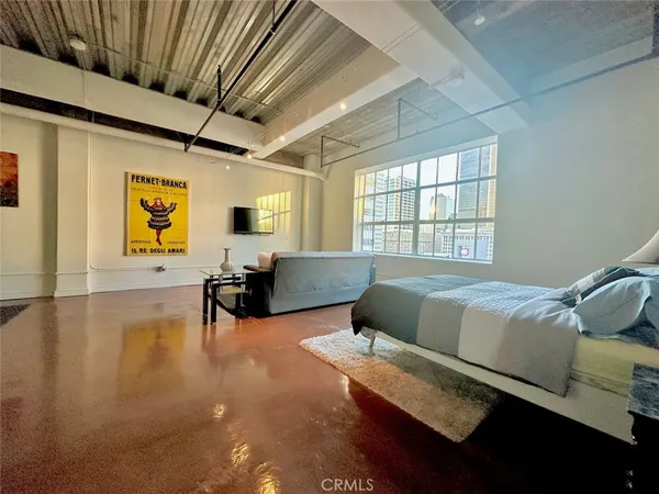 a bedroom with furniture and a large window