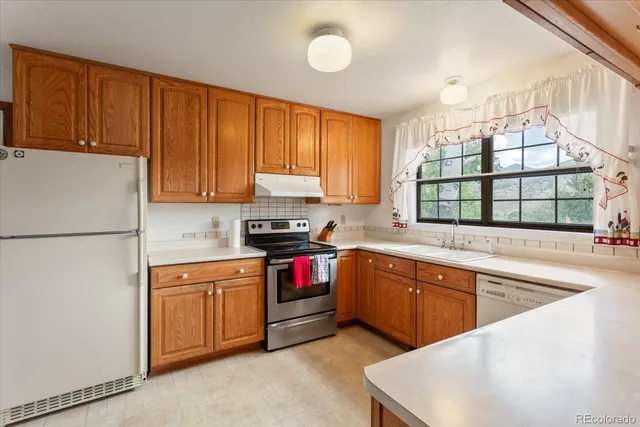a kitchen with stainless steel appliances granite countertop a sink stove and refrigerator