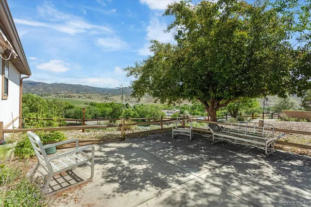 a view of a yard with furniture and wooden fence