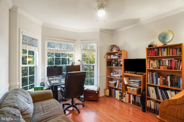 a view of a livingroom with workspace and a bookshelf