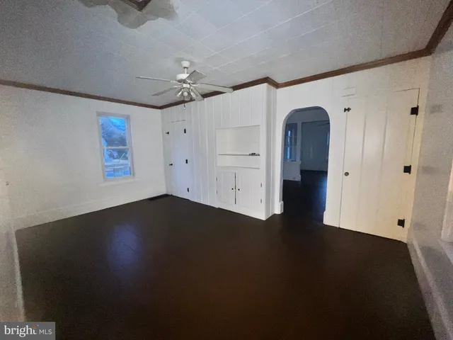 a view of a livingroom with wooden floor and a ceiling fan