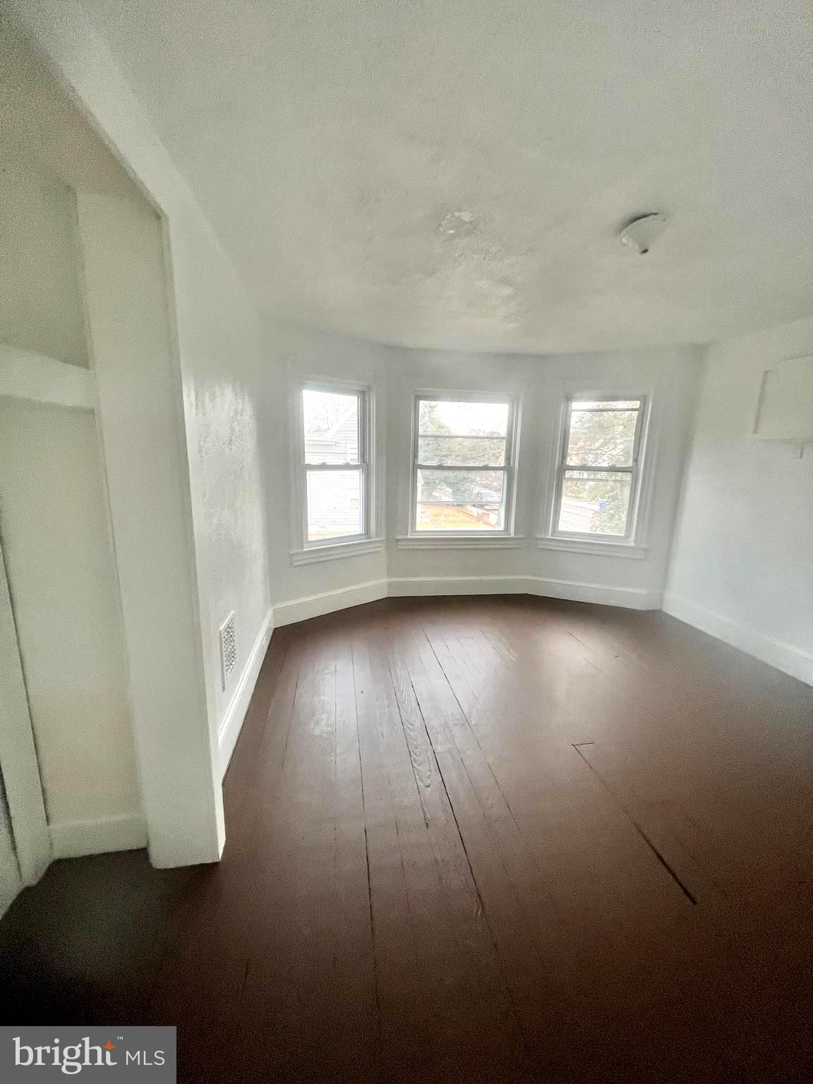302 West Main Street Millville, NJ 08332 - Photo 6 of 22 an empty room with wooden floor and windows
