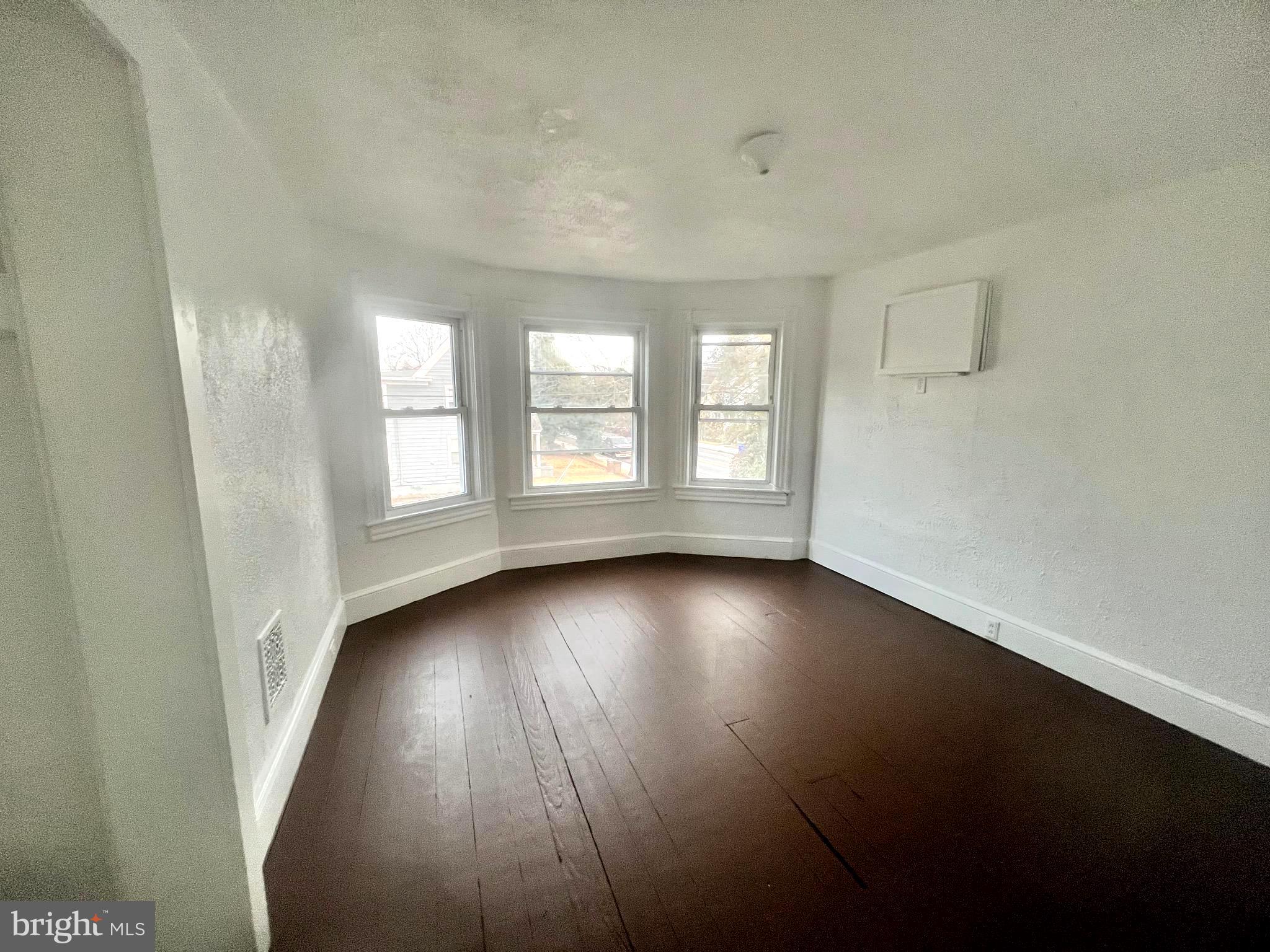 302 West Main Street Millville, NJ 08332 - Photo 7 of 22 an empty room with wooden floor and windows