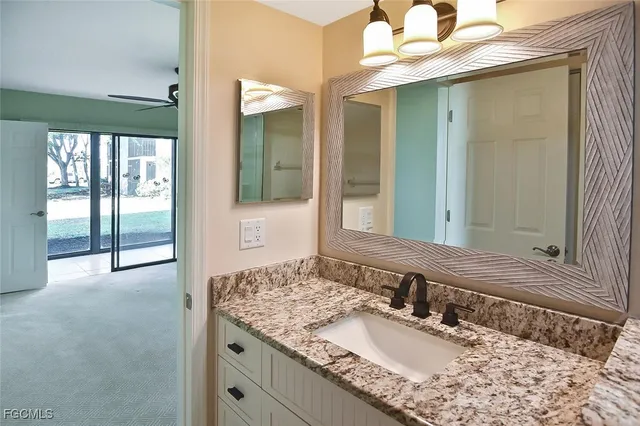 a bathroom with a granite countertop sink toilet a mirror and shower