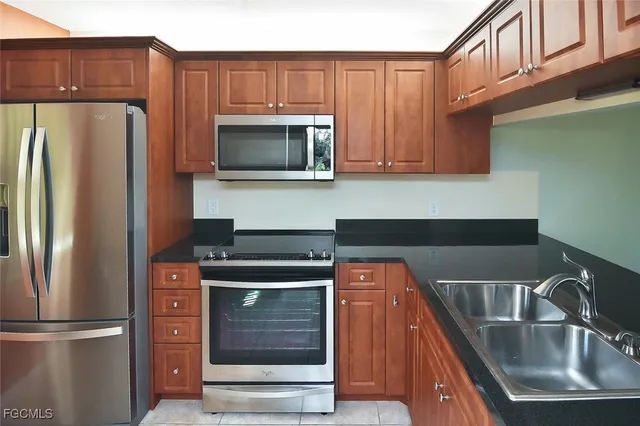 a kitchen with stainless steel appliances wooden cabinets and a stove top oven