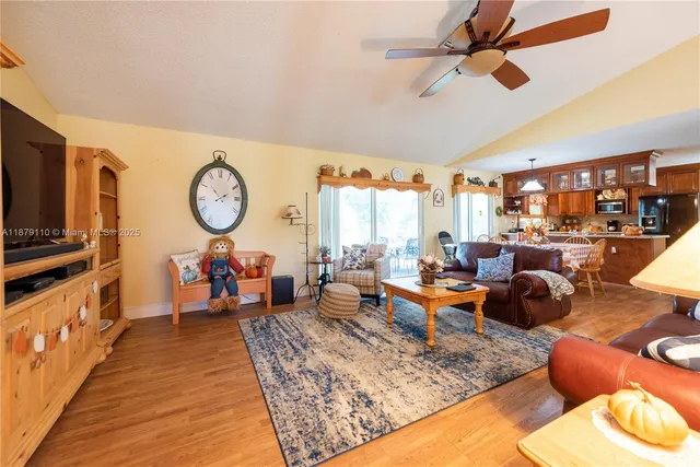 a living room with furniture kitchen view and a large window