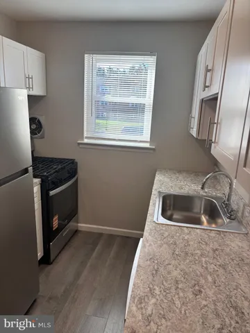 a kitchen with granite countertop a refrigerator sink and cabinets