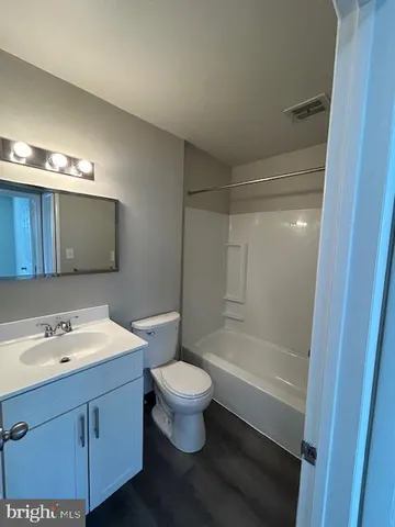 a bathroom with a sink a toilet a mirror and shower