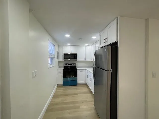 a kitchen with a refrigerator and a stove top oven